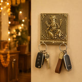 Brass-colored handcrafted lord ganesha wall-mounted key holder with intricate details and three decorative hooks for home decor