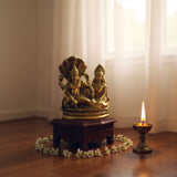 Gold brass statue of Lord Vishnu and Lakshmi Ji on wooden base with floral decorations