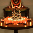 Gold Hindu deities statue of Lord Vishnu and Lakshmi on floral arrangement for worship