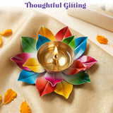 A vibrant multi-colored metal lotus brass diya with a golden center holding a lit candle for home pooja and diwali decor