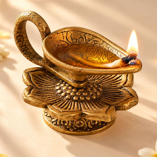Golden brass finish lotus diya oil lamp with intricate floral engravings and lit wick for pooja and indian mandir decor