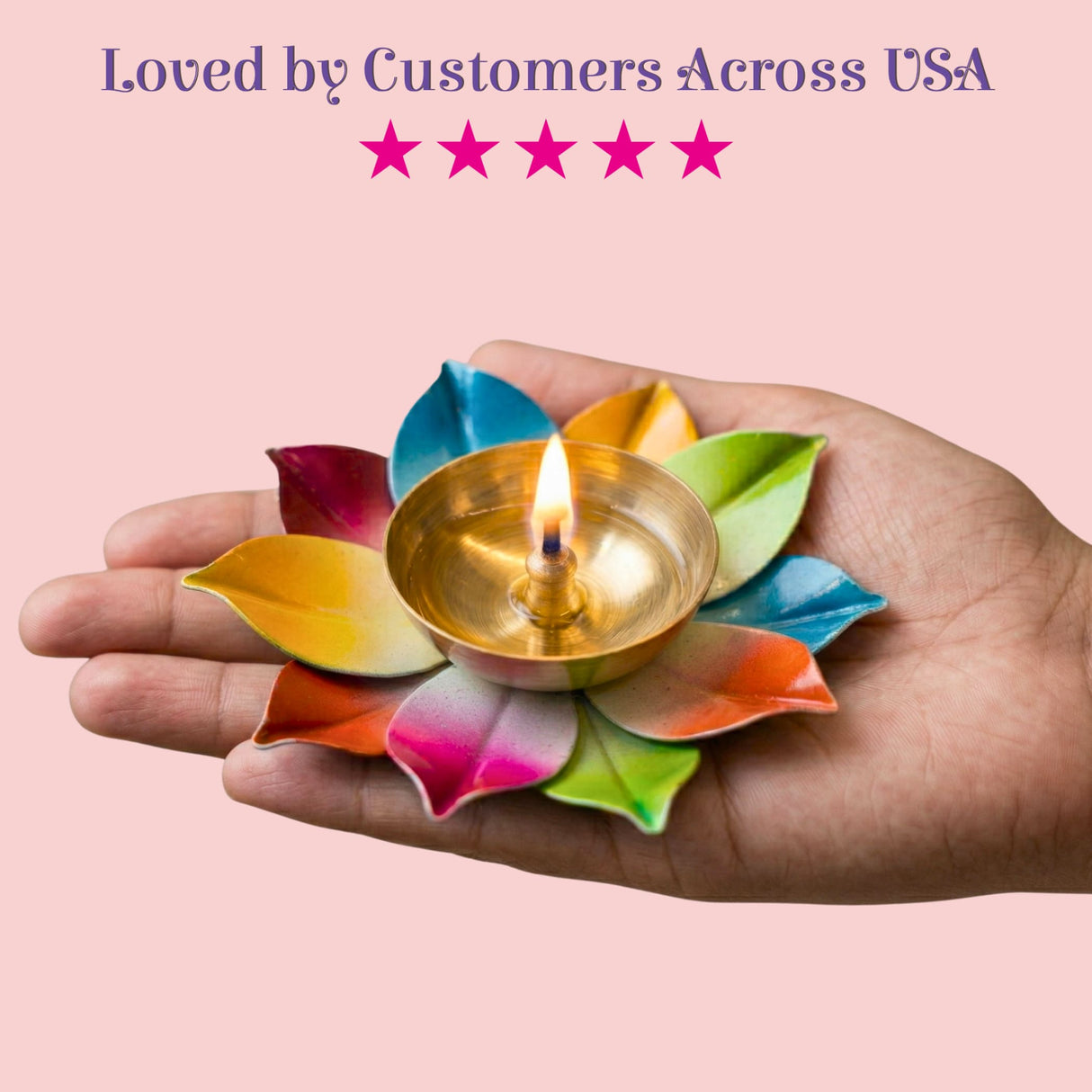 A golden brass lotus diya with a lit candle surrounded by colorful painted leaf petals for Diwali pooja decor