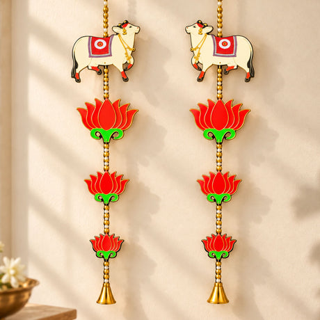 Pair of white cow wall hangings with red and gold lotus flowers and bells for Indian festival decor and pooja