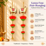 Pair of cream-colored lotus and cow wall hangings with red and gold detailing and golden beads for traditional Indian decor