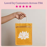 A mustard-yellow jute tote bag with a white lotus flower design and cream rope handles for bridesmaid gifts