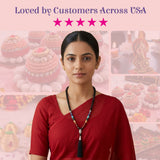 A woman wearing LOVENSPIRE 108 mala beads with black blue red beads and a silver pendant tassel for meditation