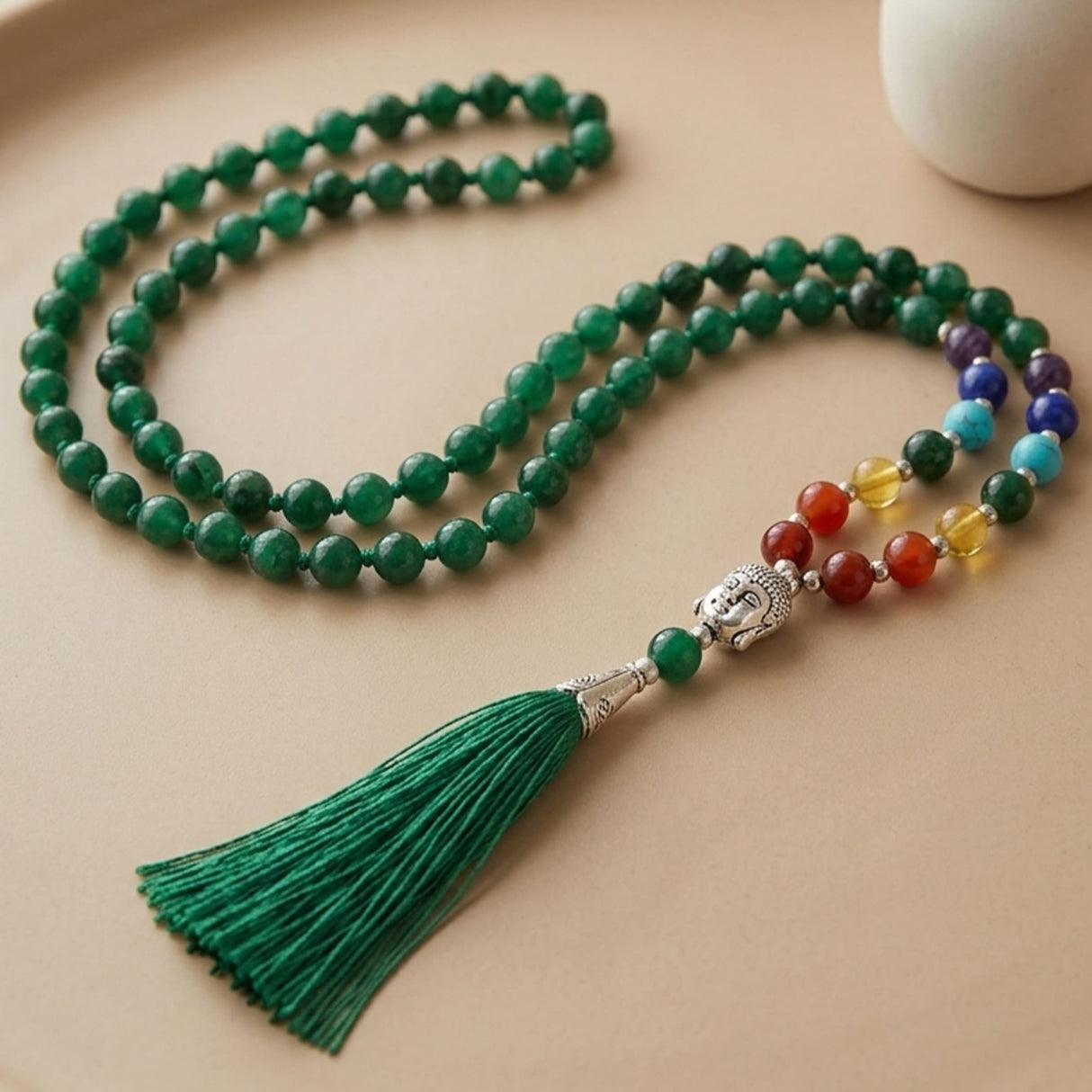 A green LOVENSPIRE 108 mala bead necklace with a silver buddha head pendant and matching tassel for meditation