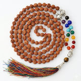 A coiled brown rudraksha mala necklace with silver buddha head bead colorful gemstones and multicolored tassel by LOVENSPIRE