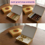 Gold-colored rectangular sweet box with ornate red green mandala lid containing assorted nuts chocolates for gifting