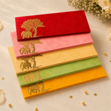 Stack of colorful velvet money envelopes with gold-embossed elephant and tree patterns for indian wedding gifts