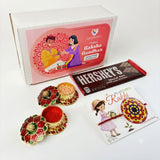 Decorative gold-toned metal gift box with red and green enamel flower designs for designer mandala seed rakhi hamper