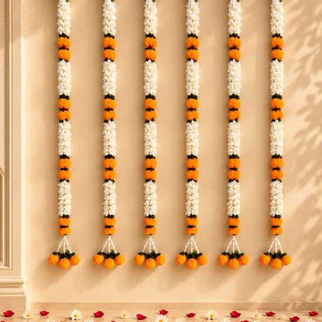 Artificial jasmine and marigold flower garlands with white and orange blossoms and green leaves for wedding and decor