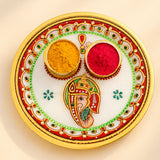 Indian white marble pooja thali with gold rim red and green floral patterns and ganesha design for hindu mandir decor