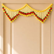 A vibrant yellow and red artificial floral garland with green accents for Indian wedding and festival door decoration