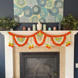 A 5 feet artificial marigold jasmine garland in vibrant orange white with green accents draped on a fireplace mantel