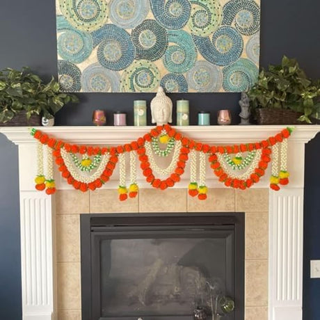 A 5 feet artificial marigold jasmine garland in vibrant orange white with green accents draped on a fireplace mantel