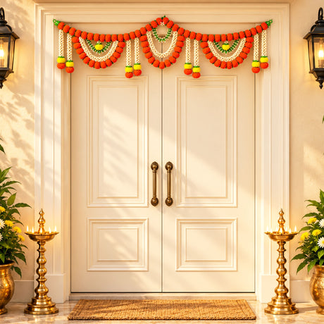 A vibrant orange and white artificial marigold jasmine garland with green accents hanging above cream double doors