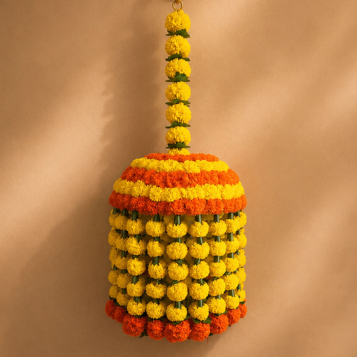 A vibrant cylindrical marigold jhoomar in yellow and orange for mehndi, wedding, diwali, and puja decorations