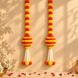 Artificial marigold and jasmine hanging jhoomer garland with vibrant orange yellow pom-poms and white tassels for festive decor