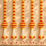 Marigold garland hanging jhoomer with vibrant orange and yellow pom-poms and white tassels for festive decor