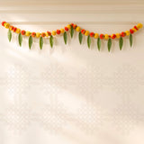 A 5 feet marigold mango leaf door toran hanging valance with vibrant red yellow flowers and green leaves for festival decor