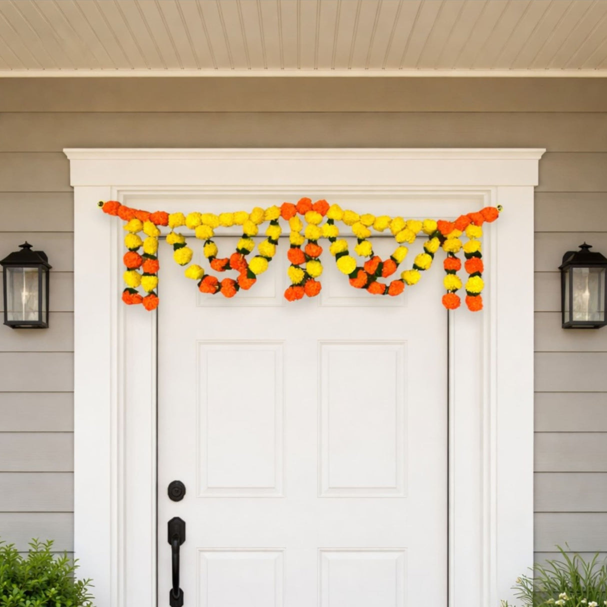 Vibrant orange marigold mango leaf door toran garland above white door