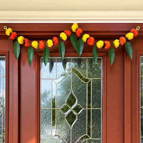 Artificial marigold flower and mango leaf garland in vibrant orange yellow with green leaves for festive decorations