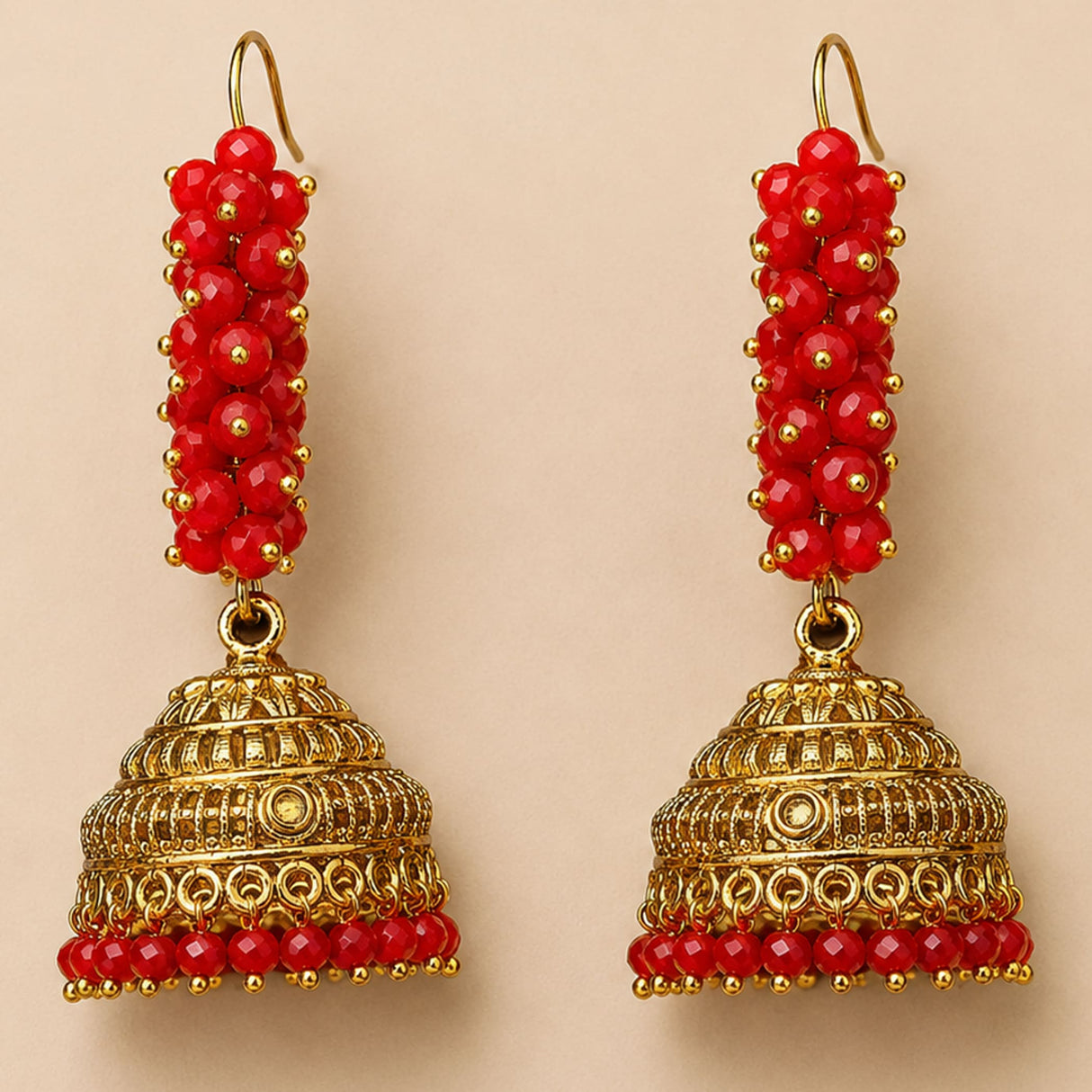 Elegant gold tone Indian Bali jhumka earrings with red faceted beads and intricate filigree for Diwali and weddings