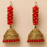 Elegant gold tone Indian Bali jhumka earrings with red faceted beads and intricate filigree for Diwali and weddings