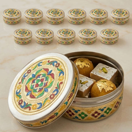 Meenakari stainless steel storage box with lid featuring ornate silver, gold, and colorful floral enamel, filled with sweets