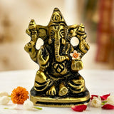 Golden brass lord ganesha car idol with intricate detailing and white flower for home decoration and pooja