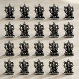Silver-colored intricately detailed metal ganesha idol figurines arranged in rows for home temple and festival decor
