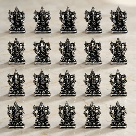 Silver-colored intricately detailed metal ganesha idol figurines arranged in rows for home temple and festival decor
