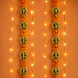 Metal leaf ganesha wall hanging decor featuring golden ganesha head ornaments adorned with orange marigold flowers