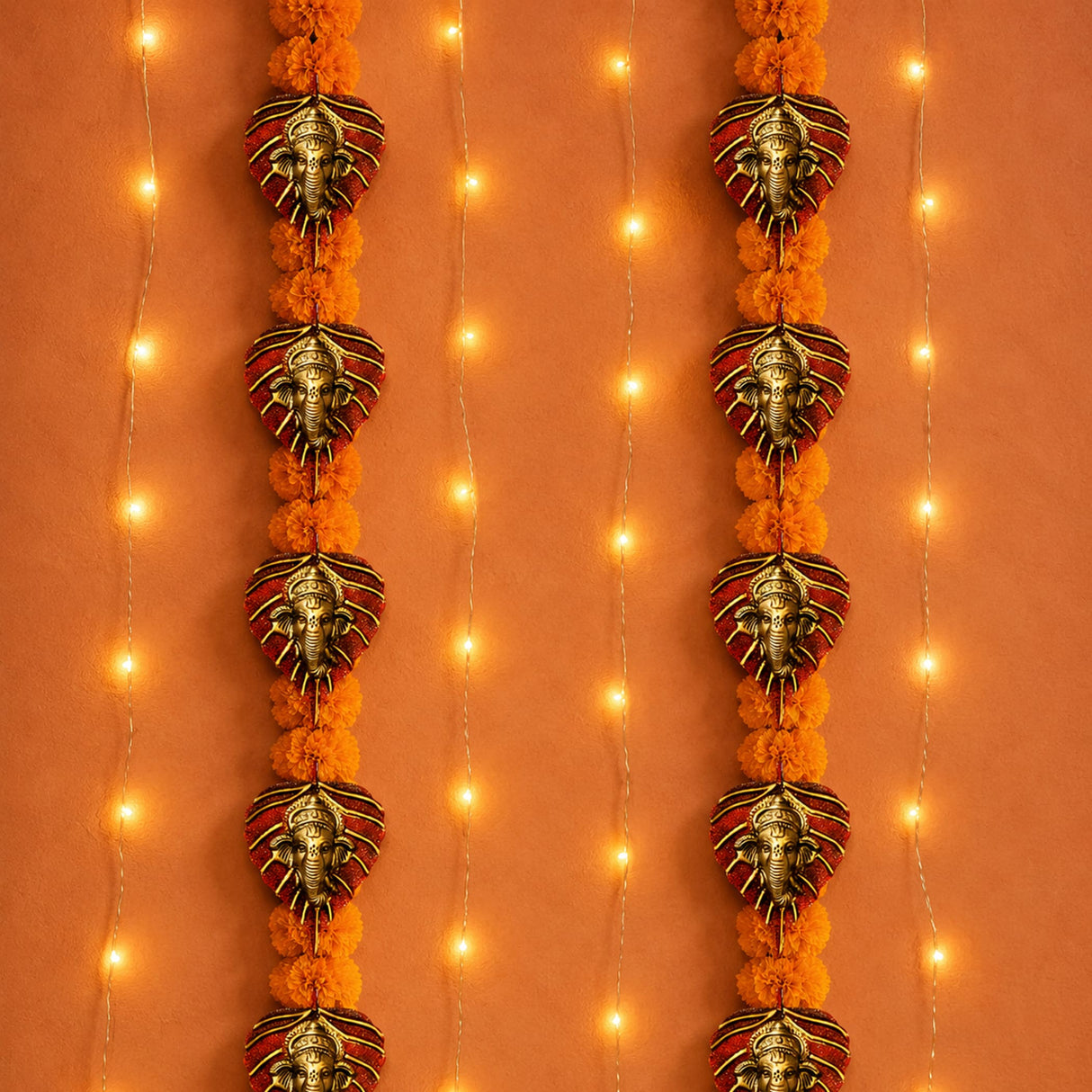 Ornamental ganesha-themed metal leaf wall hanging decor with metallic gold and red accents and marigold pom-poms