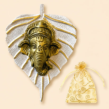 Golden ganesha metal wall hanging with intricate detailing on silver leaf background for home decor and festive gifts