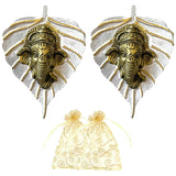 Golden ganesha head ornaments on silver leaf-shaped metal bases with decorative swirls for home and office decor