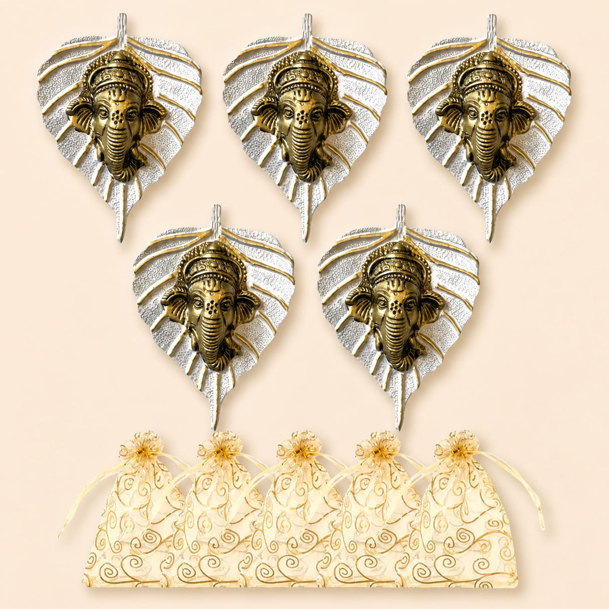 Set of five ornate brass ganesha head wall hangings with silver leaf designs and matching cream organza gift bags