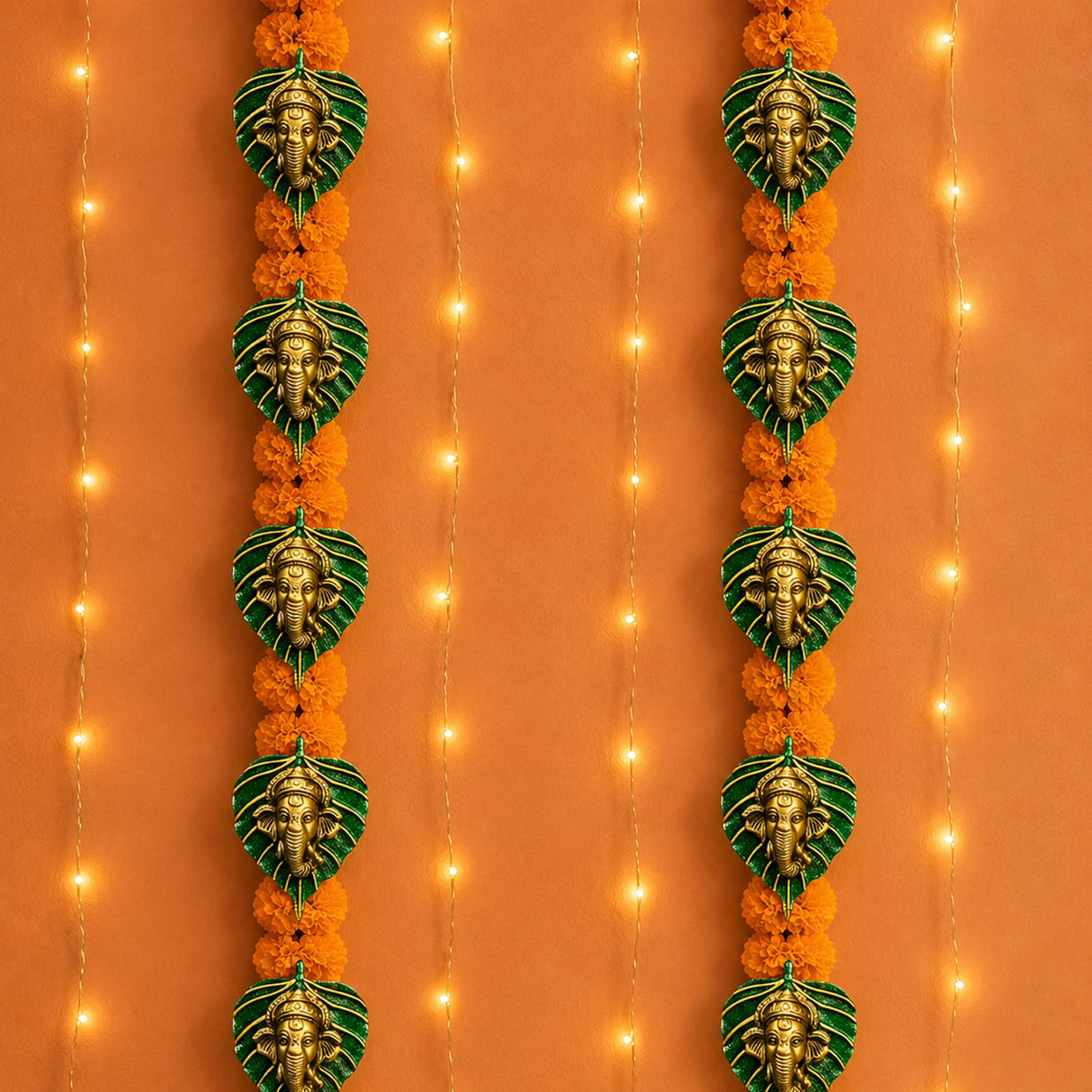 Metal leaf ganesha wall hanging decor featuring golden ganesha head on green leaf backings with orange marigold flowers for diwali and home use