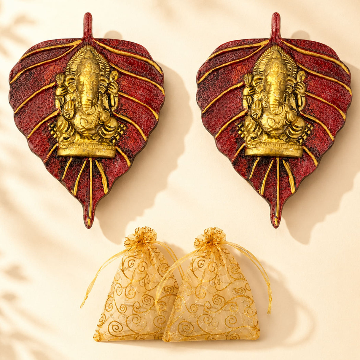 Red and gold metal leaf wall hanging featuring a golden ganesha figure for diwali decor and pooja favors