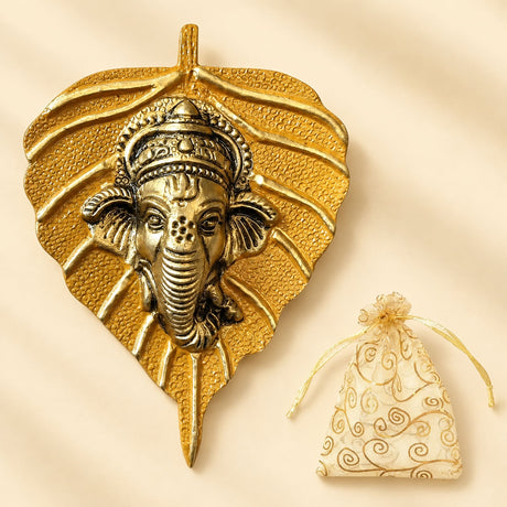 Golden metallic ganesha wall hanging shaped like a leaf with intricate detailing for home and office decor