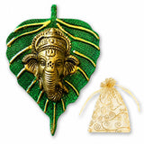 Golden metal ganesha head sculpture on textured green leaf background wall hanging decor for home and office use