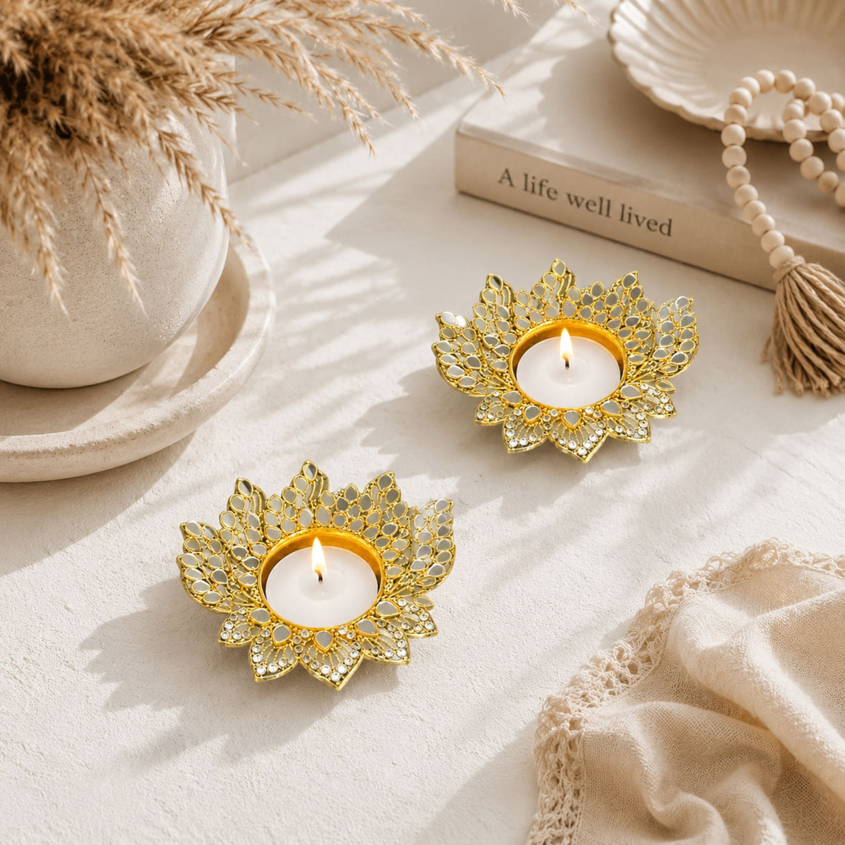 Gold-toned metal lotus candle holders with intricate design and mirrored glass accents for diwali and home temple decor