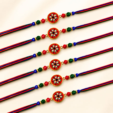 Handcrafted designer rakhi bracelets in red green and blue thread with gold-toned enamel floral charms and beads