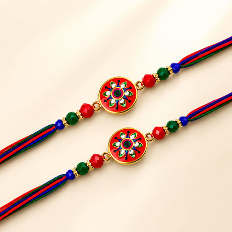 Handcrafted designer rakhi with vibrant red and gold enamel floral pendant and multicolor thread for brother and bhabhi