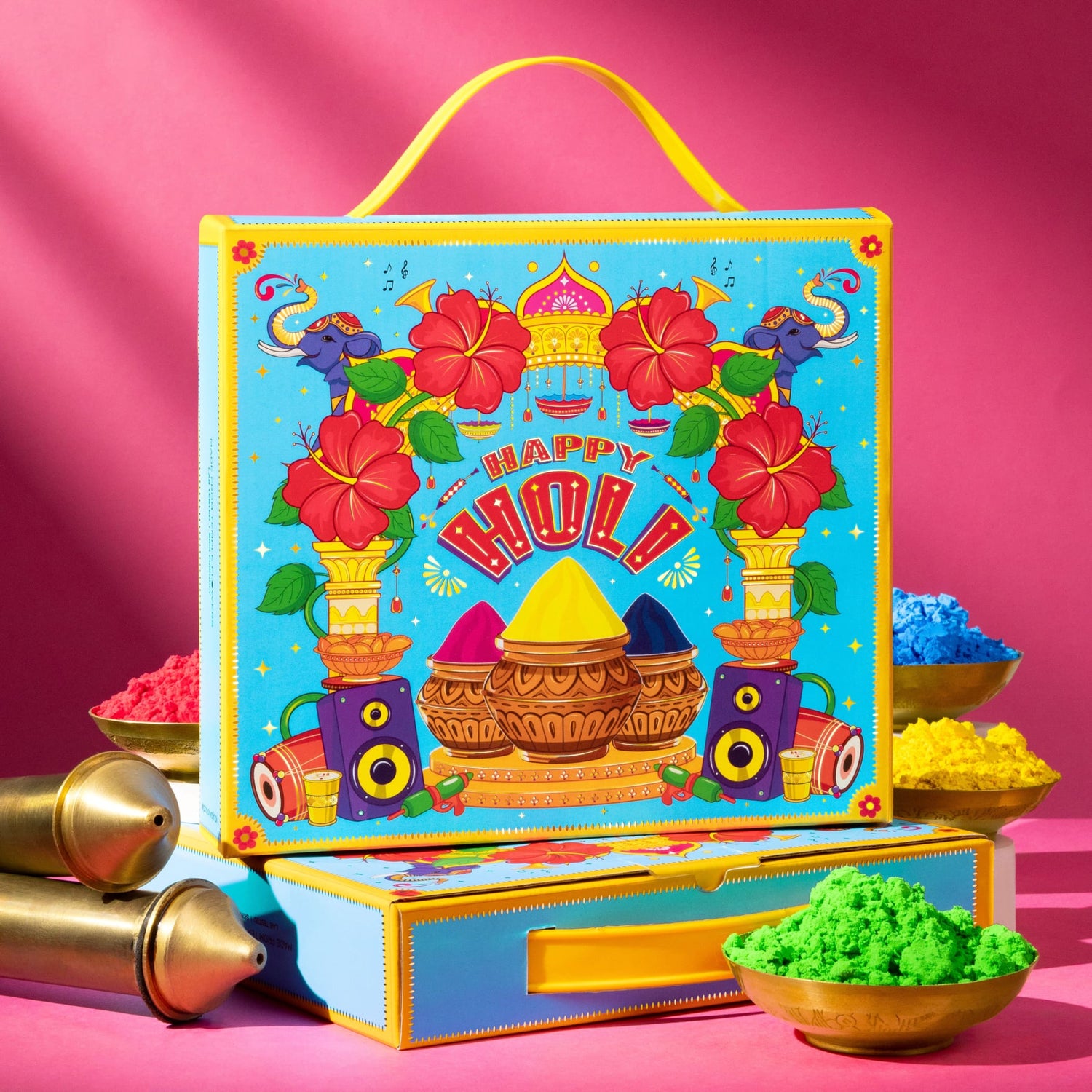Vibrant Holi gift box with blue-yellow colors, elephants, hibiscus, pots, speakers