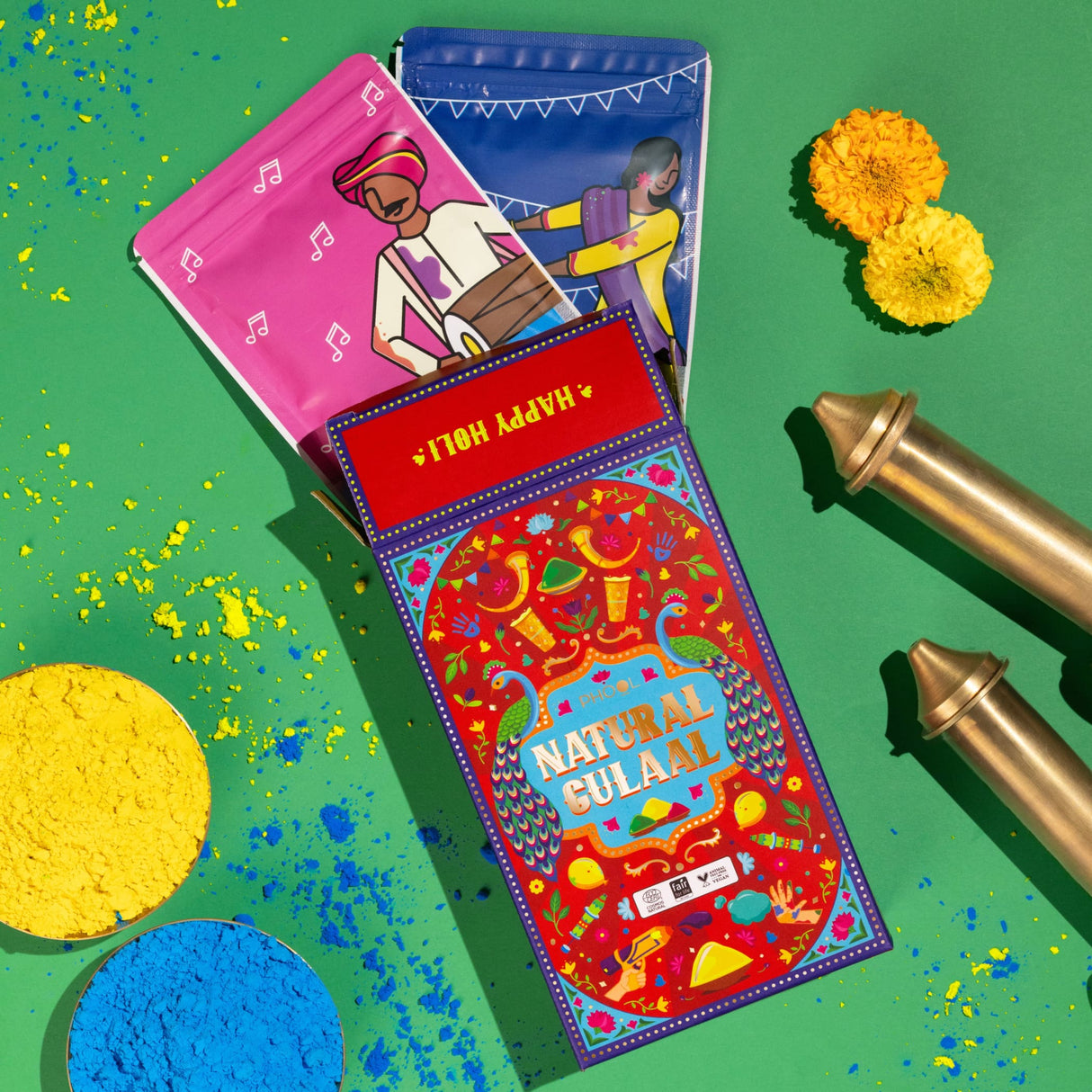 Vibrant red box of natural Holi gulal powder with colorful illustrations and Happy Holi banner