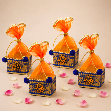 Pack of 4 blue and gold ornate small potli gift boxes with orange sheer organza bags and blue pom-poms for Indian festivals
