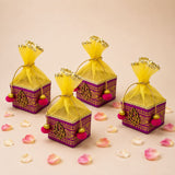 Pack of 4 small purple and gold net potli gift boxes with embroidered ganesha motifs and yellow organza bags for indian weddings