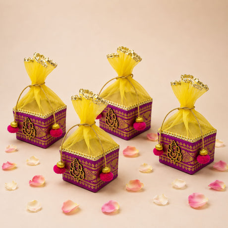 Pack of 4 small purple and gold net potli gift boxes with embroidered ganesha motifs and yellow organza bags for indian weddings